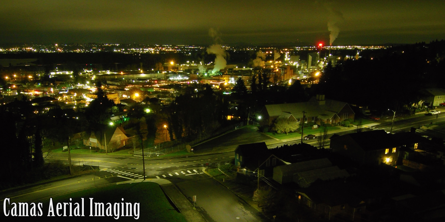 Downtown Camas, WA at night, with the Columbia River and Portland Metro in the background.